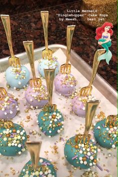 little mermaid cake pops with gold and blue frosting