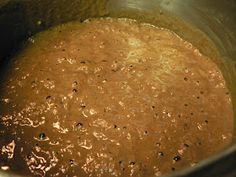 a pot filled with brown liquid sitting on top of a stove