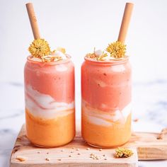 two jars filled with food sitting on top of a wooden board next to each other