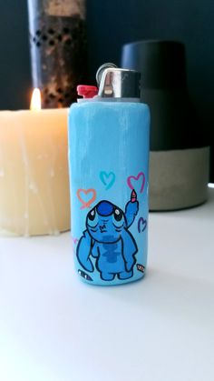 a blue flask with an elephant on it next to a lit candle