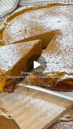 a pumpkin pie is cut into slices on a wooden cutting board with powdered sugar