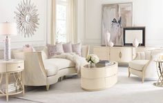 a living room filled with white furniture and lots of pillows on top of the couches