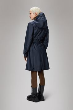 Curve W Jacket is a clean women's raincoat with a slightly shaped silhouette accentuating the waist. Designed to block out water, wind and chill. This design with a minimal silhouette is Rains' interpretation of the women's trenchcoat. The design is figure-flattering with high functionality. Curve Jacket is a weather-ready staple designed with a drawstring hood with built-in cap, coated zip closure with snap-fastened placket and snap adjustment at sleeve cuffs. The look is completed with two fro Fall Raincoat With Double-lined Hood And Nylon Material, Classic Long Single-breasted Raincoat, Functional Raincoat With Double-lined Hood And Long Sleeves, Winter Raincoat With Double-lined Hood In Nylon, Rain Jacket Women, Long-sleeved Nylon Raincoat With Pockets, Pu Fabric, Elegant Drapes, Raincoats For Women