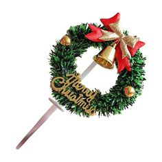 a christmas wreath on top of a toothpick with a bell hanging from it