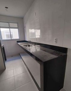 an empty kitchen with black and white counter tops