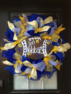 a blue and yellow mesh wreath with the words go wild on it's front door