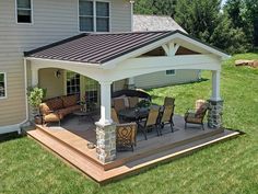 a covered patio with chairs and table on it