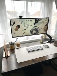 a computer monitor sitting on top of a wooden desk next to a keyboard and mouse