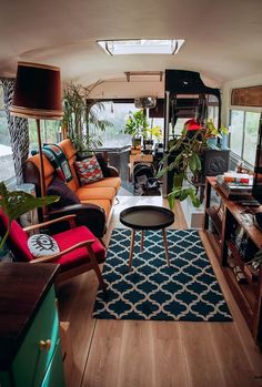 a living room filled with furniture and lots of plants on top of a wooden floor