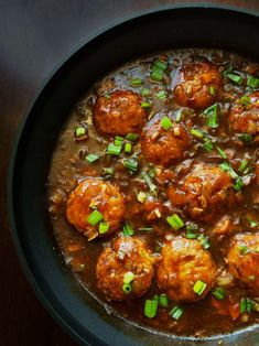 meatballs and gravy in a skillet with green onions