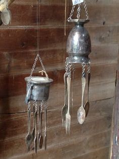 three metal pots and spoons hanging on a wall