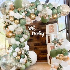 a baby shower is decorated with balloons and greenery