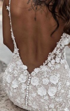 the back of a woman's wedding dress, with flowers and pearls on it