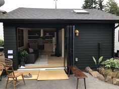 an outside view of a small house with patio furniture