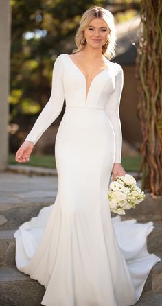 a woman in a white wedding dress is walking down some steps