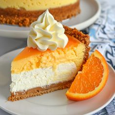 a slice of cheesecake with whipped cream on top and an orange slice next to it