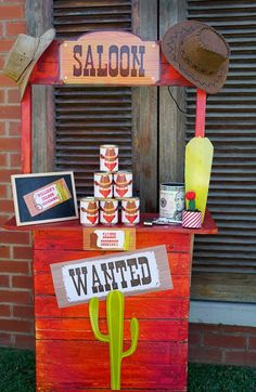 a sign that says saloon is on top of a wooden stand with various items around it