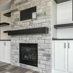 a fireplace with white cabinets and black mantle