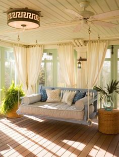 the sun shines through the windows onto a porch with couches and potted plants