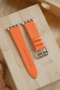 Entirely handmade Orange Epsom French Calfskin watch strap. The leather Epsom comes from the French Tannery Haas and is used by many luxury brands for their leather watch straps. Epsom is incredibly durable leather as it is highly resistant to scratches. It is supple to the touch, with an embossed grain. Unlike many other examples listed on Etsy, this strap is entirely hand-stitched. Please note that this strap is ONLY available for the Apple Watch.  We currently offer three lengths: Standard (115mm/75mm) (wrist size from 6.5 inch to 7.25 inches) Short (105mm/70mm) (wrist size 5.5 inches to 6.75 inches) Long ( 125mm/80mm ( Wrist sizes 7.25 inches to 8.75 inches) Our watch straps are lined with Zermatt Calfskin from the tannery Haas, which is a hypoallergenic and water resistant calfskin. Luxury Leather Bracelet Strap Apple Watch Band, Adjustable Leather Watch Strap, Luxury Adjustable Leather Apple Watch Band, Leather Watch Bands With Adjustable Strap, Rectangular, Leather Watch Bands With Adjustable Strap, Leather Watch Band With Adjustable Strap, Rectangular, Rectangular Leather Watch Band With Adjustable Strap, Luxury Leather Bracelet Strap Watch Bands, Leather Rectangular Watch Bands With Palladium Hardware