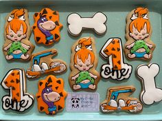 decorated cookies in the shape of cartoon characters are displayed on a tray with bones and bones