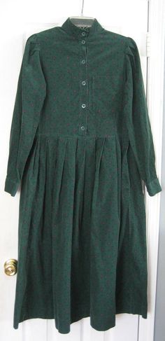 Preowned 1980s Vintage Laura Ashley Dark Green Fine Wale Pinwale Corduroy Cottagecore Modest Prairie Dress With High Collar & Subtle Foulard or mall Diamond Floral Print.  Size 4-6-8. Size label states Size 8, but it is a 1980s Size 8 that may fit those who wear Size 4 or 6 -see measurements below. The long sleeve dress is made with a somewhat fitted bodice with a left breast pocket. It has a full skirt with gathered pleats below the waistline. It is made of dark forest green fine wale cotton co Cotton Vintage Dress For Fall Daywear, Vintage Winter Daywear Dresses, Classic Green Cotton Dress, Laura Ashley Clothing, Eighties Fashion, Pioneer Dress, Vintage Laura Ashley, Laura Ashley Dress, Cottagecore Fashion