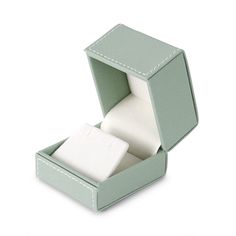 an open green box with two rolls of toilet paper in it on a white background