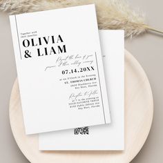 two wedding cards on a plate next to a feathery object with the word, oliva & llam