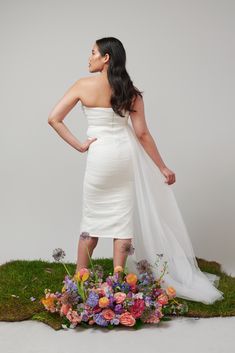 a woman in a white dress is standing with her hands on her hips