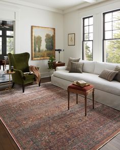 a living room filled with furniture and large windows