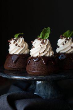 three chocolate desserts with whipped cream and mint leaves