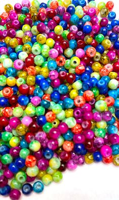 multicolored beads are scattered on a white surface, including one with an odd shape