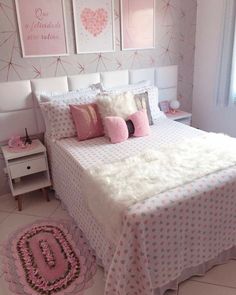 a bedroom with pink and white decor on the walls, bedding and rugs