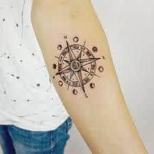 a person with a compass tattoo on their arm