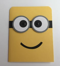 a close up of a yellow card with eyes and a smiley face on it's front