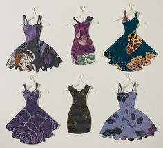 six dresses are hanging on clothes pins in the shape of an animal and giraffe