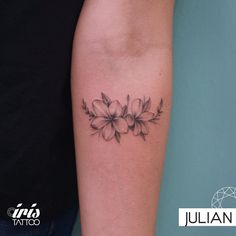 a black and white photo of a woman's arm with flowers tattooed on it