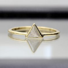 a gold ring with a white diamond on it