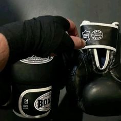 a person wearing boxing gloves and black gloves with white writing on the inside of them