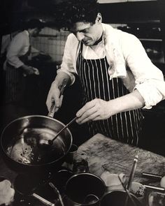 a black and white photo of a man cooking