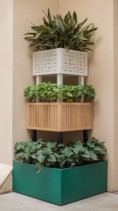 three tiered planter with green plants in it on the side of a building