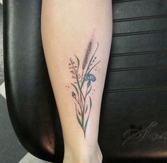 a woman's foot with a flower tattoo on her left leg and the bottom part of her arm