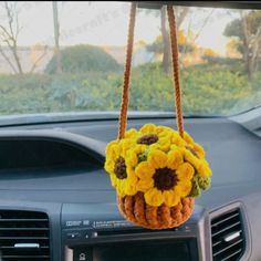 a sunflower purse hanging from the dashboard of a car