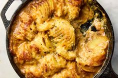 a skillet filled with chicken and potatoes