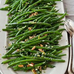 a white plate topped with green beans and almonds