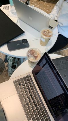 an open laptop computer sitting on top of a table next to a cup of coffee