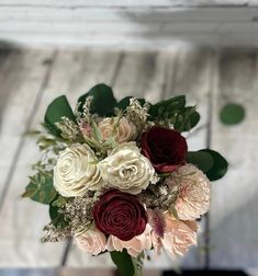 a bouquet of flowers sitting on top of a wooden table