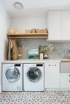 a washer and dryer sitting in a kitchen next to each other on top of a tiled floor