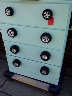 an old dresser has wheels on it and is painted light blue with black trims