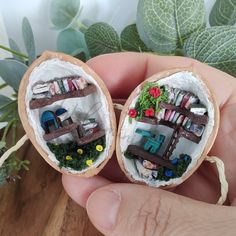 two miniature figurines made to look like they are in an egg shell with grass and flowers on the inside